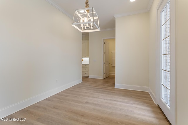 unfurnished dining area with crown molding, light wood-style flooring, baseboards, and an inviting chandelier