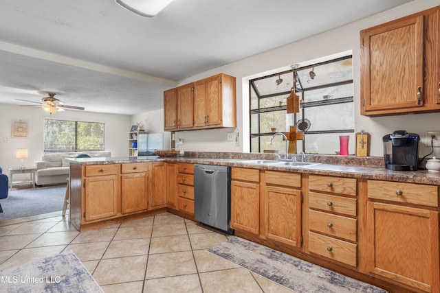 kitchen with sink, stainless steel dishwasher, ceiling fan, light tile patterned flooring, and kitchen peninsula