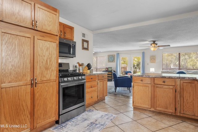 kitchen with appliances with stainless steel finishes, french doors, a textured ceiling, ceiling fan, and light tile patterned flooring