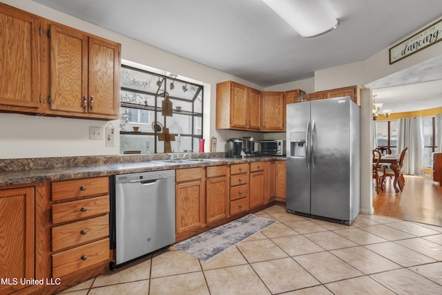 kitchen with sink, light tile patterned flooring, a chandelier, and appliances with stainless steel finishes