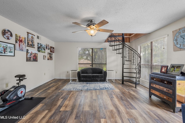 living area featuring a textured ceiling, ceiling fan, and dark wood-type flooring