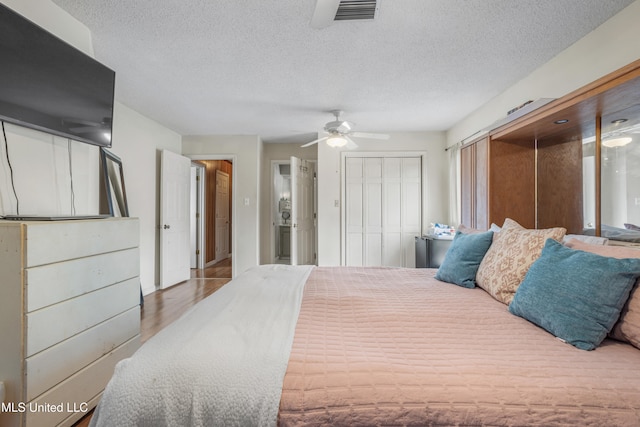 bedroom with wood-type flooring, a textured ceiling, and ceiling fan