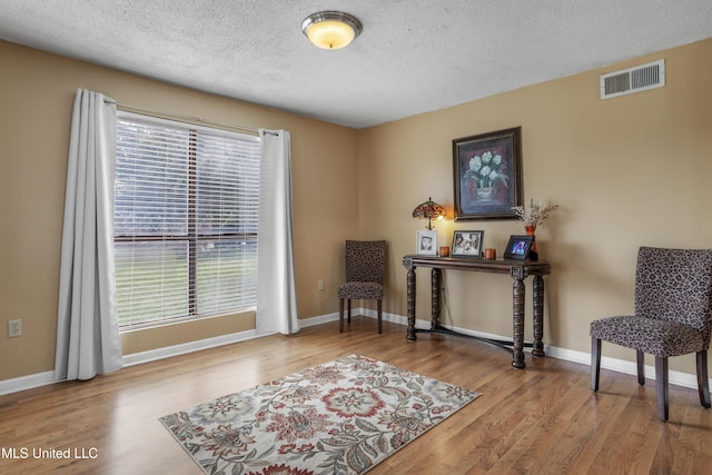 sitting room featuring hardwood / wood-style floors and a textured ceiling