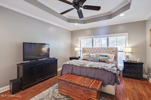 bedroom featuring crown molding, a tray ceiling, and wood-type flooring