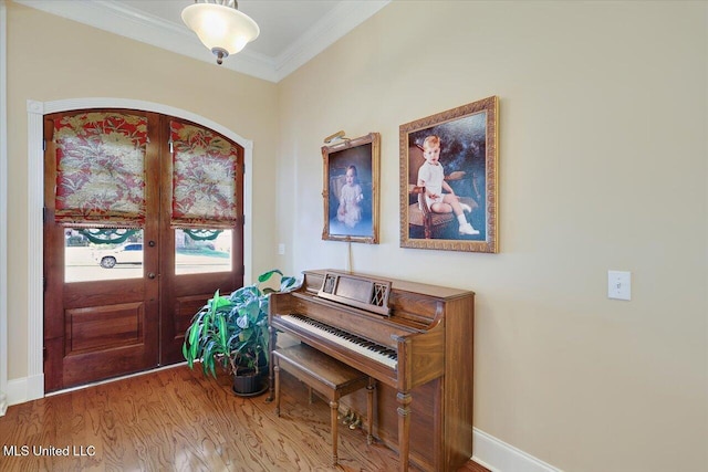 foyer featuring hardwood / wood-style flooring, crown molding, and french doors