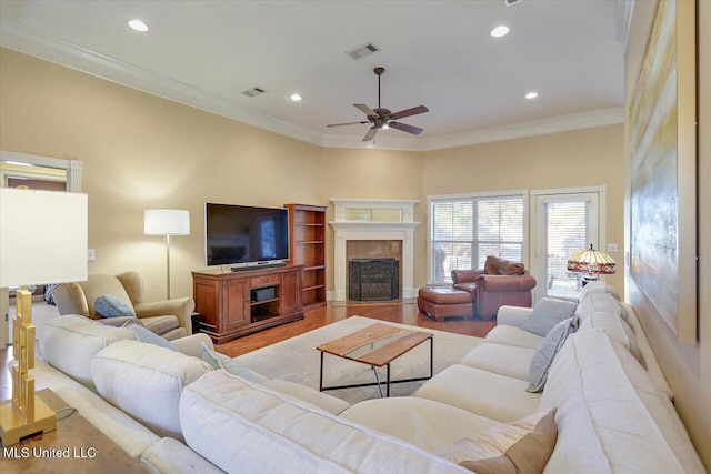 living room featuring crown molding, ceiling fan, and light hardwood / wood-style flooring