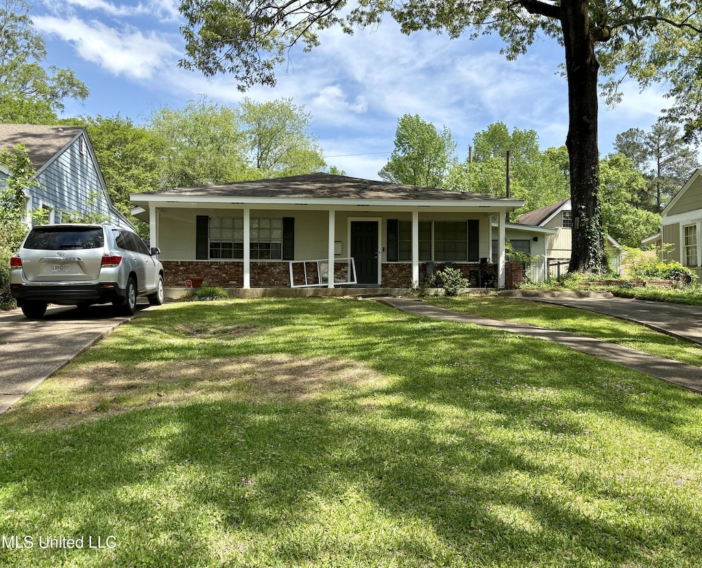 bungalow-style home featuring covered porch, brick siding, and a front yard