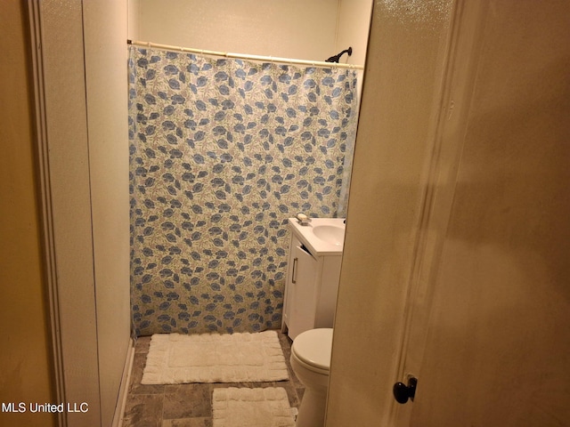 full bathroom featuring a shower with curtain, vanity, and toilet