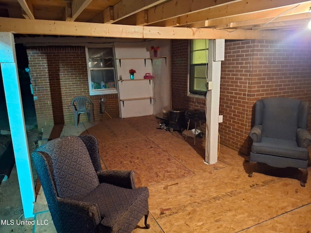 sitting room featuring brick wall