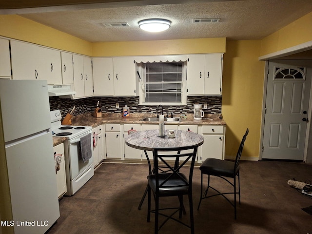 kitchen featuring white appliances, visible vents, a sink, white cabinets, and under cabinet range hood