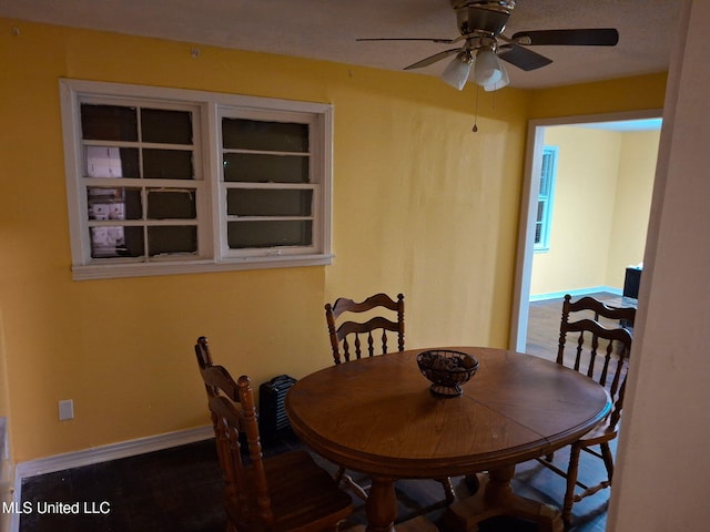dining space with baseboards and a ceiling fan