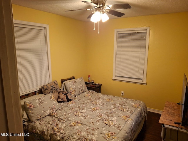 bedroom featuring a textured ceiling, baseboards, and a ceiling fan