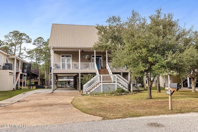 view of front of home with a carport, a front yard, covered porch, and ceiling fan