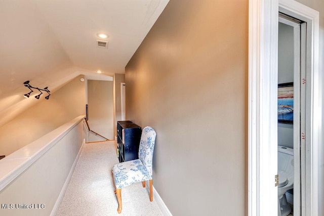 hall with carpet flooring and vaulted ceiling