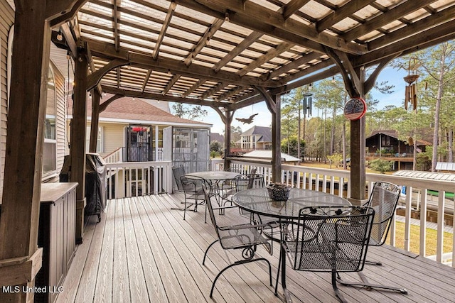 wooden deck featuring a pergola and a sunroom