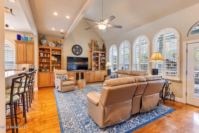 living room featuring ceiling fan, lofted ceiling with beams, a healthy amount of sunlight, and light hardwood / wood-style floors