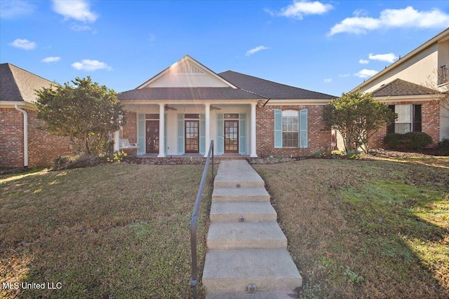 view of front of house with a ceiling fan, brick siding, a porch, and a front lawn