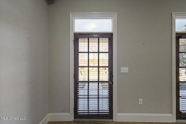 doorway to outside with baseboards