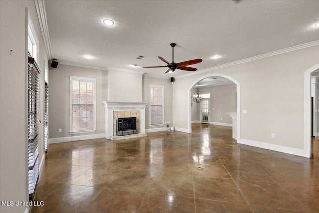 unfurnished living room featuring arched walkways, ornamental molding, a fireplace, and baseboards