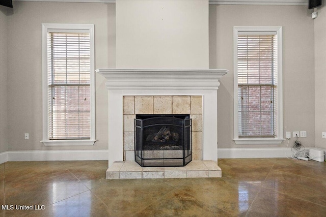 details with baseboards and a tiled fireplace