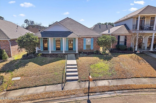 view of front facade featuring a balcony, a porch, and a front yard