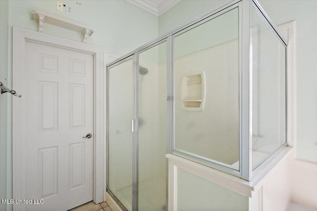 full bathroom featuring ornamental molding, a shower stall, and tile patterned floors