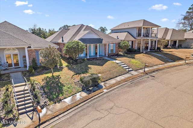 view of front of home with a front yard and a balcony