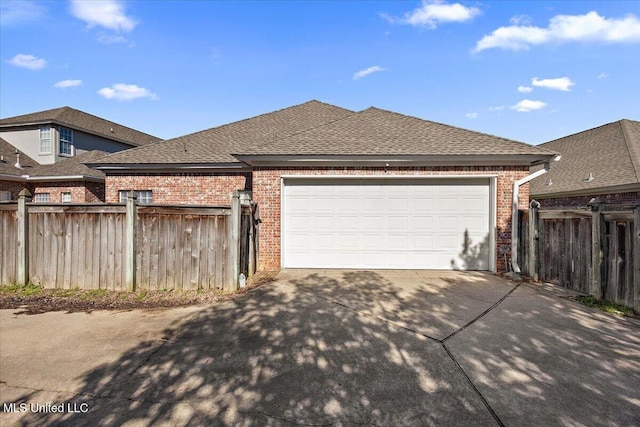 view of front of property featuring a shingled roof, brick siding, fence, and driveway