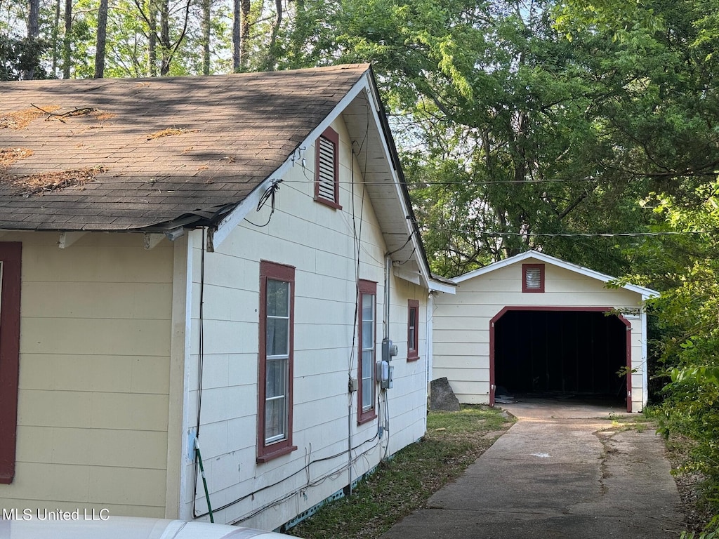 view of property exterior with a garage and an outbuilding