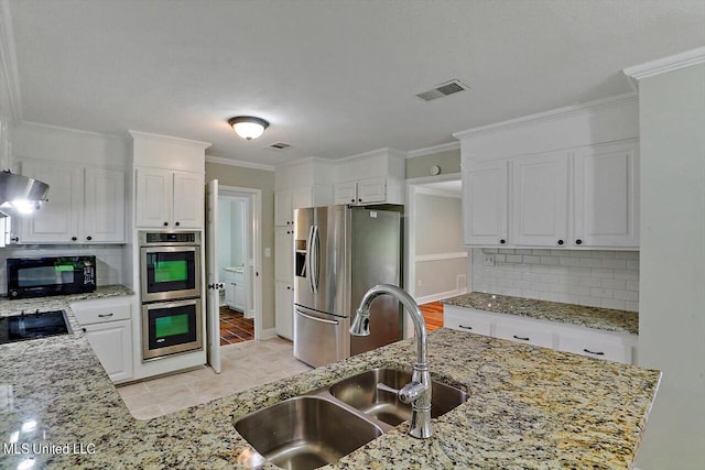 kitchen with sink, light stone countertops, black appliances, white cabinetry, and tasteful backsplash