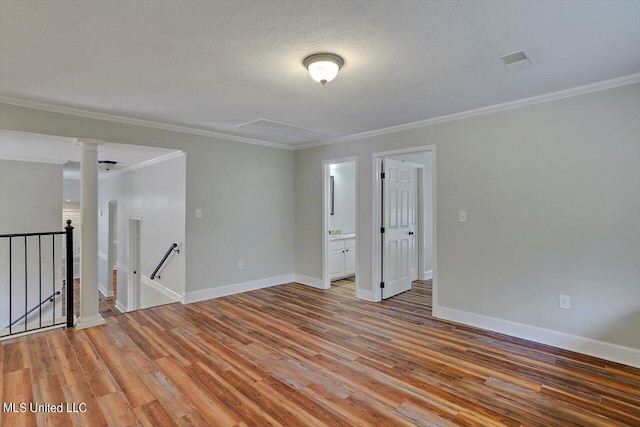 unfurnished room with crown molding, a textured ceiling, and hardwood / wood-style flooring