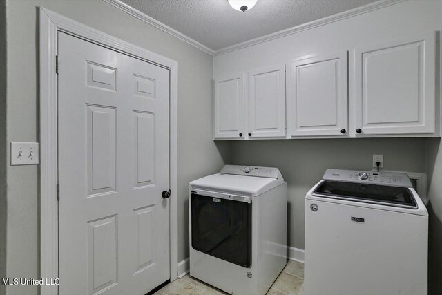 4441 Wedgewood St, Jackson, MS 39211 - washroom featuring a textured ceiling, baseboards, ornamental molding, washing machine and clothes dryer, and cabinet space