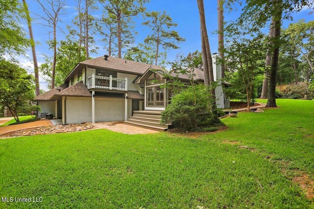 4441 Wedgewood St, Jackson, MS 39211 - view of front of house featuring a balcony, stucco siding, roof with shingles, and a front lawn