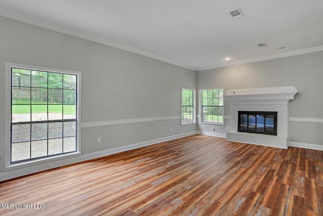 unfurnished living room featuring crown molding, hardwood / wood-style flooring, and a brick fireplace