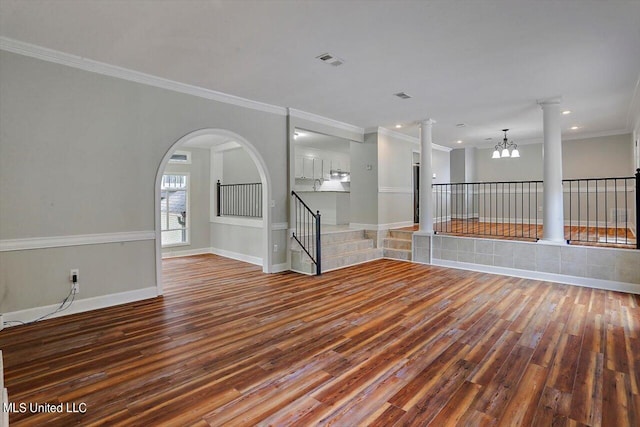 spare room with ornamental molding, an inviting chandelier, and hardwood / wood-style floors