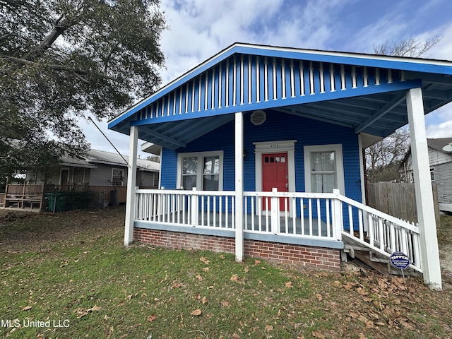 view of front of house with covered porch and a front yard