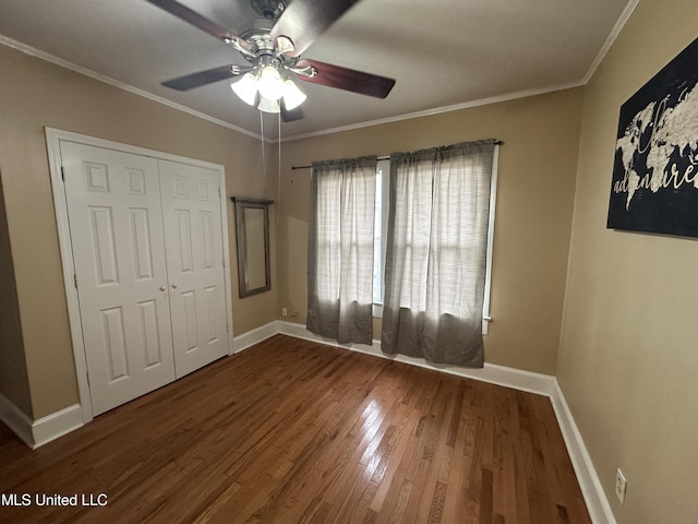 unfurnished bedroom with ceiling fan, ornamental molding, wood-type flooring, and a closet