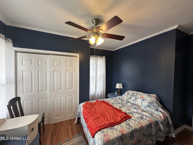 bedroom with crown molding, hardwood / wood-style floors, ceiling fan, and a closet