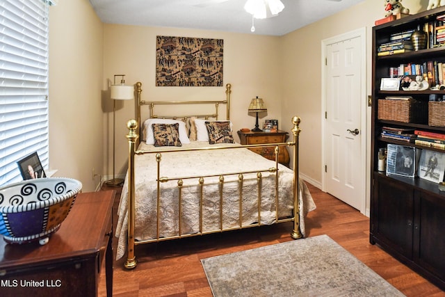 bedroom with multiple windows, ceiling fan, and dark hardwood / wood-style floors