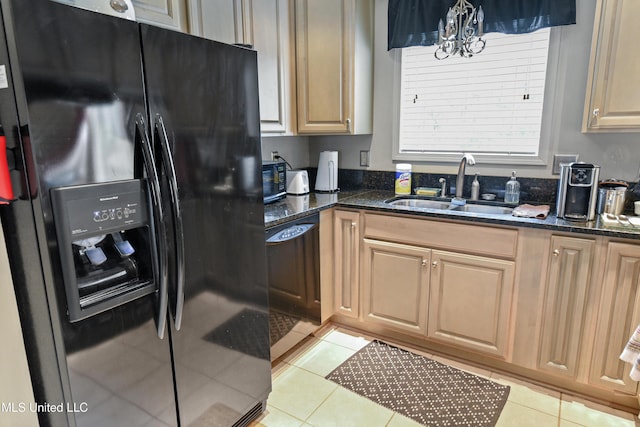 kitchen with sink, a notable chandelier, dark stone countertops, light tile patterned floors, and black appliances