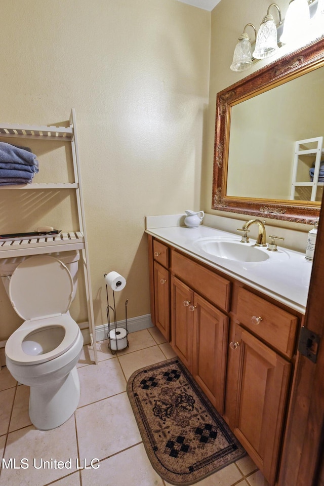 bathroom with toilet, vanity, and tile patterned floors