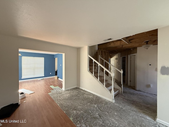 interior space featuring stairs, wood finished floors, visible vents, and baseboards