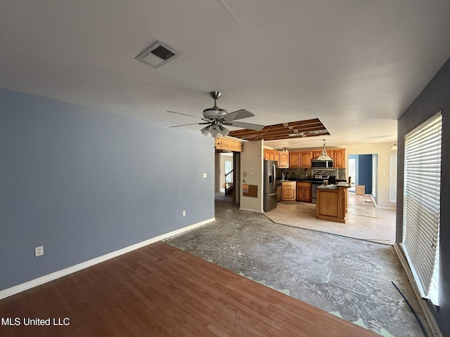 unfurnished living room with visible vents, baseboards, and a ceiling fan