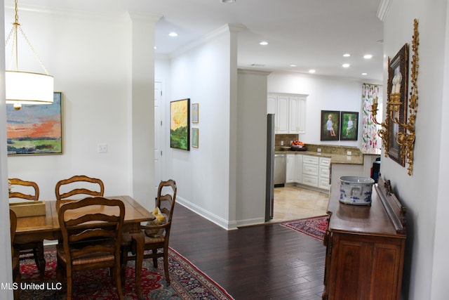 dining area with light wood-type flooring, crown molding, baseboards, and recessed lighting