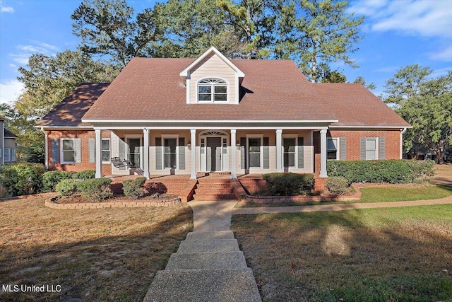 new england style home with a front yard and a porch