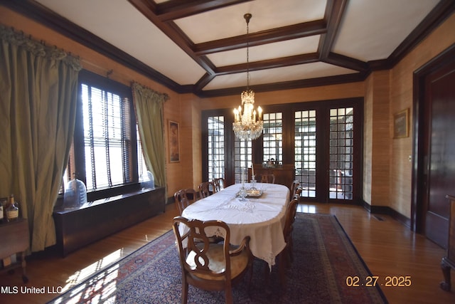 dining room featuring coffered ceiling, wood finished floors, an inviting chandelier, crown molding, and beam ceiling