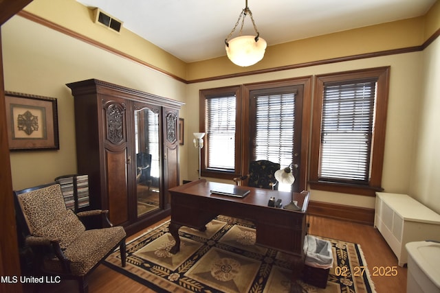 office space with visible vents, baseboards, and wood finished floors