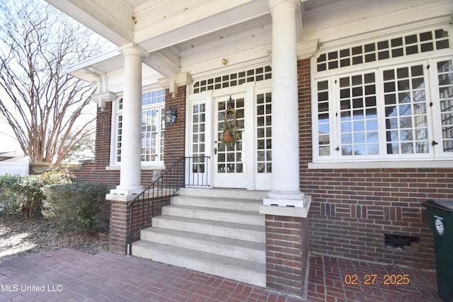 view of exterior entry featuring brick siding