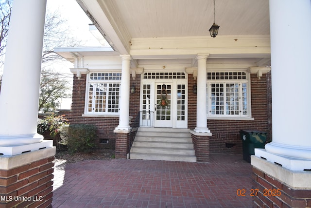 entrance to property featuring crawl space and brick siding