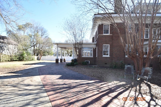 view of front of property with brick siding, crawl space, and fence